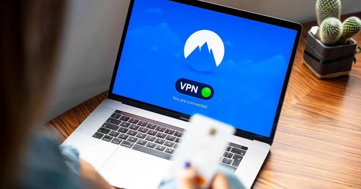 A person using a VPN on a laptop, symbolizing secure internet browsing in a modern indoor setting. macbook pro on brown wooden table