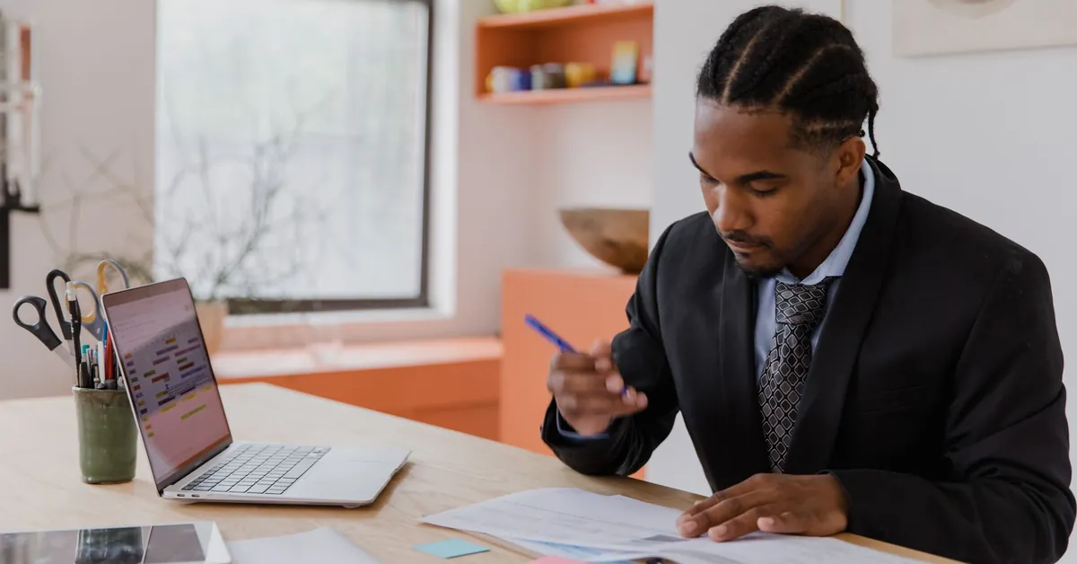 A professional businessman working at his desk, reviewing documents in a modern office environment. businessman signing documents in his office