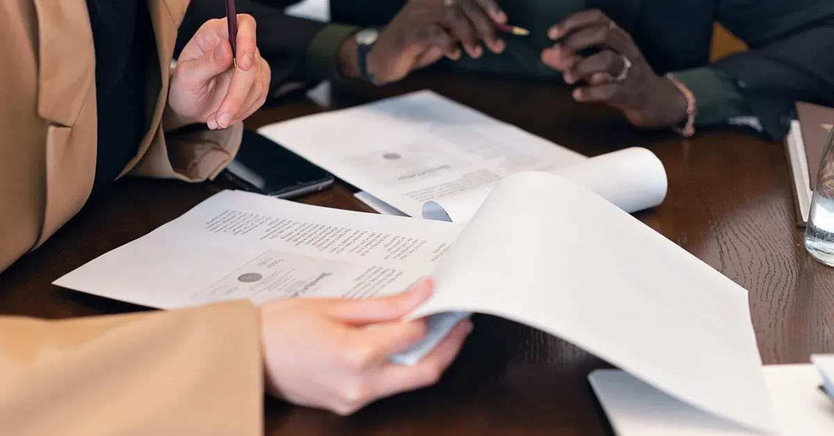 Close-up of professionals reviewing documents during a business meeting in an office setting. a close up shot of people reviewing documents