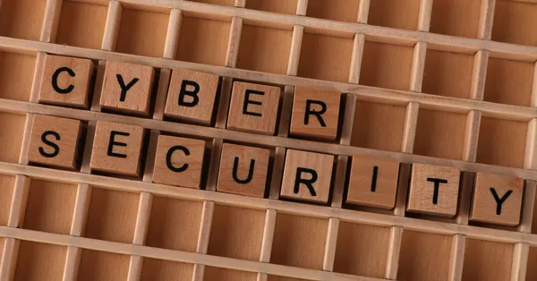 Wooden letter blocks spelling 'CYBER SECURITY' on a wooden grid background for data protection themes. wooden blocks spelling cyber security concept