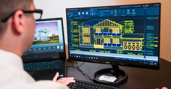 An architect reviews detailed house designs on dual monitors in a modern office setting. architect working on a computer