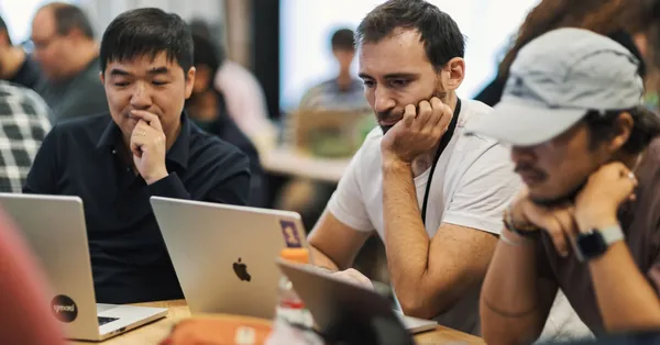 A diverse group of professionals working together on laptops in a modern office environment. focused team collaborating on laptops in office setting