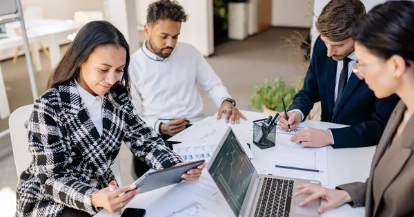Business team engaged in planning and analysis with laptops and papers at a modern office. a group of people working together