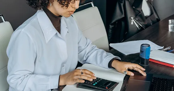 Young woman in office using a calculator for financial calculations. an accountant using a calculator