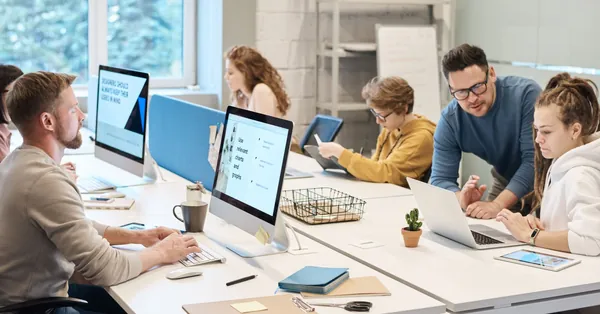 Team collaboration in a modern office setting with computers and diverse employees working together. people working in front of the computer